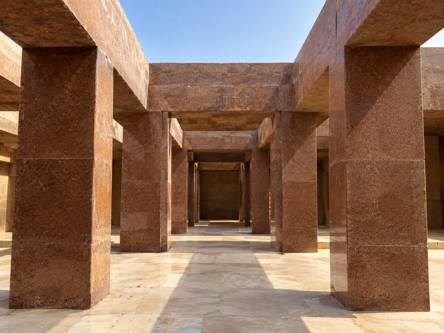 Mächtige Pfeiler und Stürze aus rotem Granit im Taltempel des Chephren, Sonnenlicht fällt auf den hellen Boden